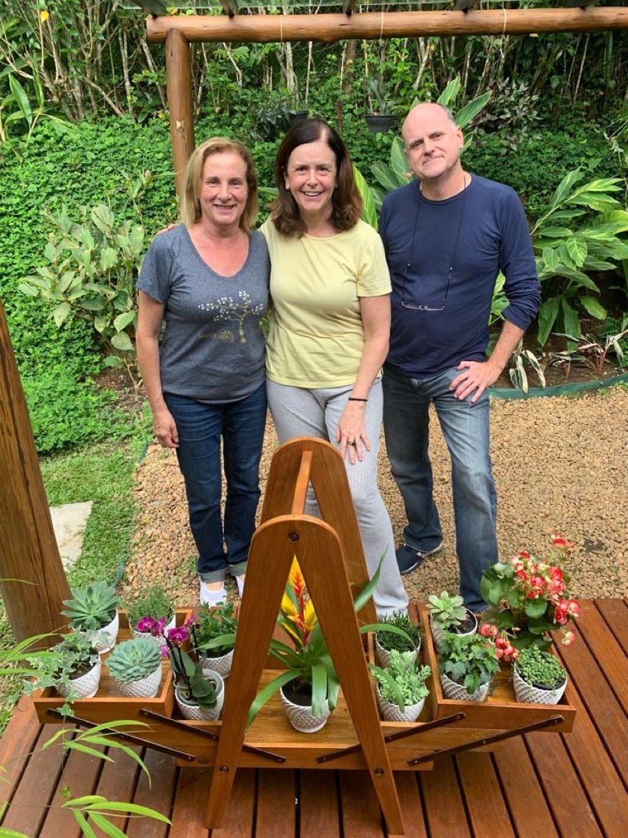 Anelise com floreira artesanal Via Legno em jardim residencial